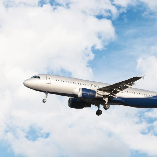 airplane-flying-cloudy-sky-min
